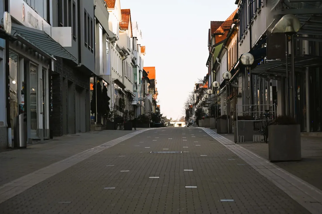 Menschenleere Einkaufsstraße mit geschlossenen Läden am frühen Morgen